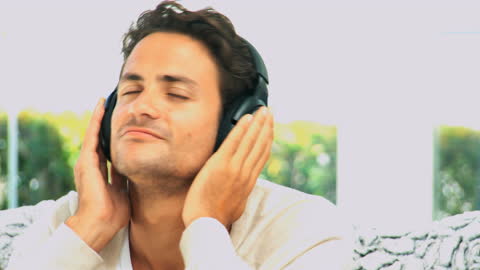Serene Man Enjoying Music Through Headphones