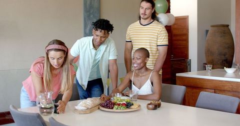 Diverse friends enjoying snacks at home gathering