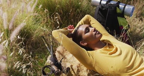 Female Hiker Resting on Rock in Mountain Scenery