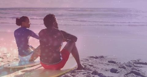 Couple Sitting on Surfboards Watching Ocean at Pastel Sunset Beach Romantic Coastal Moment