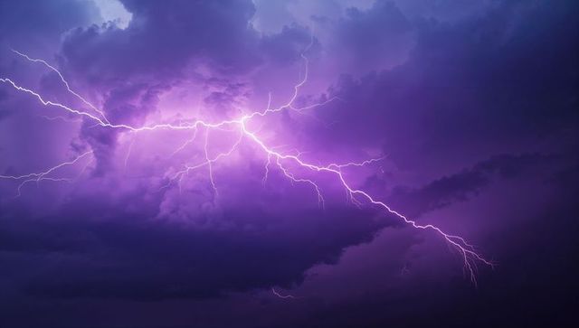 Branching Lightning Across Purple Thunderclouds at Night