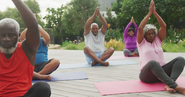 Diverse group of senior men and women performing yoga on mats in an outdoor park, focusing on wellness and an active lifestyle. This can be used for health and wellness campaigns, senior fitness programs, yoga promotions, and community engagement activities.