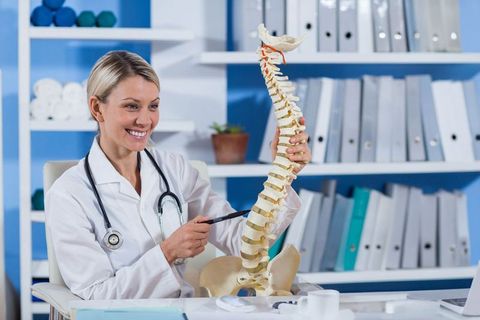 Female Doctor Explaining Spine Anatomy at Medical Office