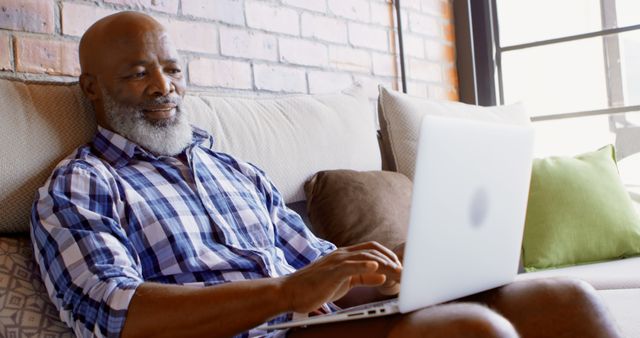 Senior Adult Man Relaxing on Couch Using Laptop in Bright Living Room - Download Free Stock Images Pikwizard.com