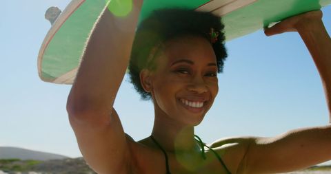 Smiling Woman Carrying Surfboard at Sunny Beach