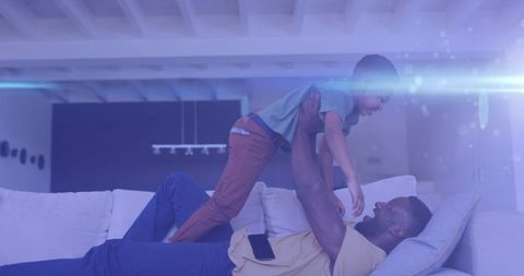 Joyful African American Father and Son Playing on Couch