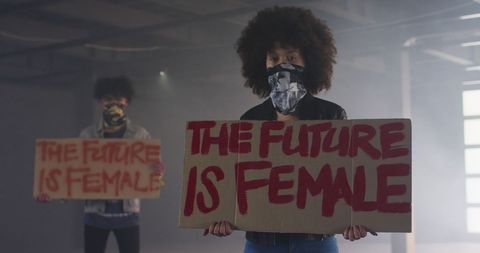 Activists holding protest signs for gender and racial equality