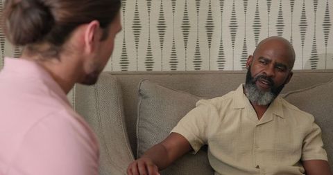 Two Men Discussing Few Issues at Home on Sofa