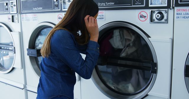 Young Woman Waiting for Laundry to Dry in Laundromat - Download Free Stock Images Pikwizard.com