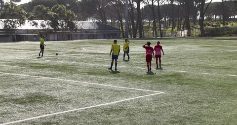 Youth soccer match in sunlit stadium emphasizing teamwork