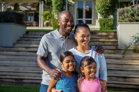 Diverse family bonding outdoors in suburban home setting