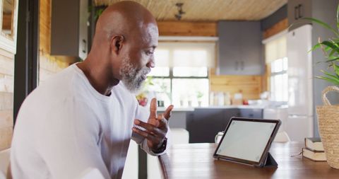 Elderly Man Engaging in Video Call on Tablet Indoors