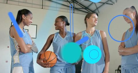 Four women basketball players smiling and chatting on indoor court with graphic overlays