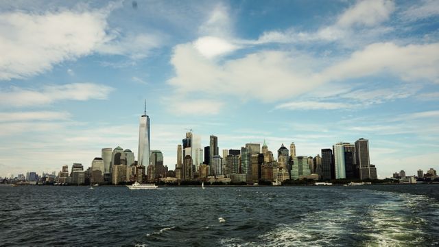 Manhattan's iconic skyline featuring the One World Trade Center viewed from the water on a bright day. Ideal for use in travel brochures, blogs, and tourism websites showcasing New York City. This image highlights the architectural beauty and urban splendor of NYC, making it perfect for promoting travel and exploration.