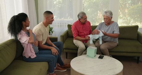 Diverse family sharing joyful pregnancy news in cozy living room