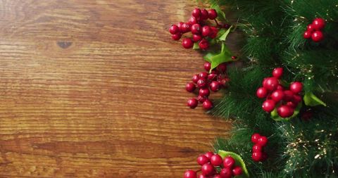 Framing Rustic Wood with Evergreen Garland and Red Berries for Festive Holiday Design