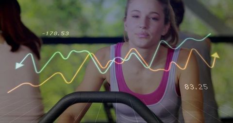 Young woman pedaling on stationary bike with biometric HUD overlay and performance graphs