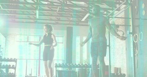 Fitness partners jumping rope performing cardio and endurance training in sunlit studio gym