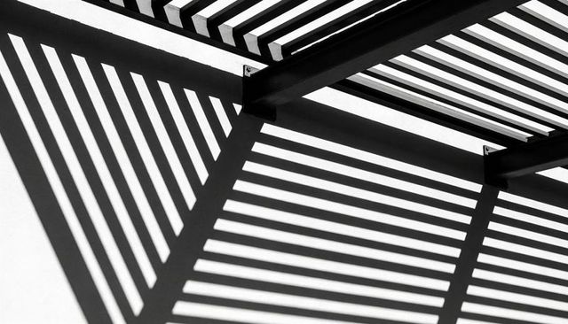 Diagonal Shadow Pattern from Metal Louver Sunshade Creating Strong Geometric Contrast