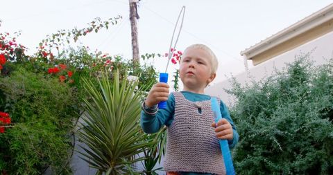 Young Boy Joyfully Playing with Bubble Wand in Lush Garden