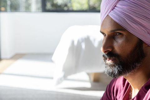 Serene man in light pink turban contemplating morning light