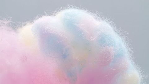 Fluffy pastel cotton candy showing macro texture and colorful pink blue yellow fibers