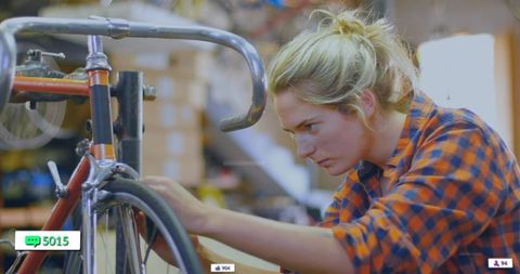 Skilled Female Mechanic Focusing on Bicycle Wheel Adjustment