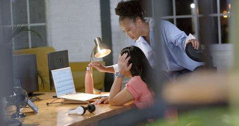 African American Businesswoman Assisting Colleague During Late Night Work