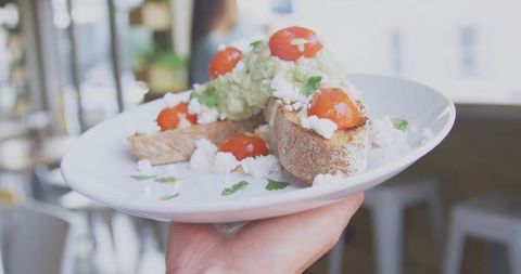Gourmet avocado toast with cherry tomatoes and fresh cheese