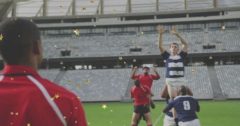 Lifting jumper reaching for ball during rugby lineout while coach in red jacket watching