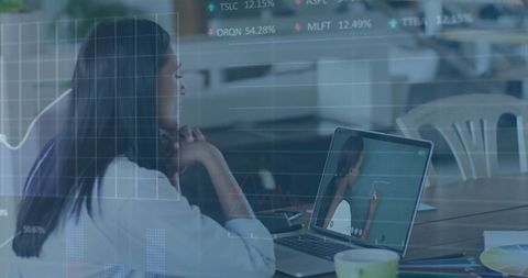 Businesswoman Analyzing Data on Laptop in Modern Cafe Environment