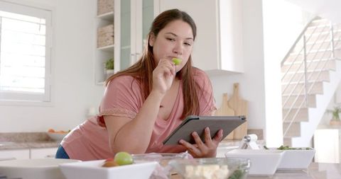 Woman Creating Healthy Meal in Kitchen with Tablet Technology - Download Free Stock Images Pikwizard.com