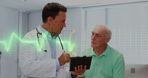 Doctor Explaining ECG Waveform to Elderly Patient on Tablet