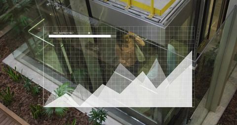 Coworkers standing in glass elevator with digital data overlay and indoor greenery