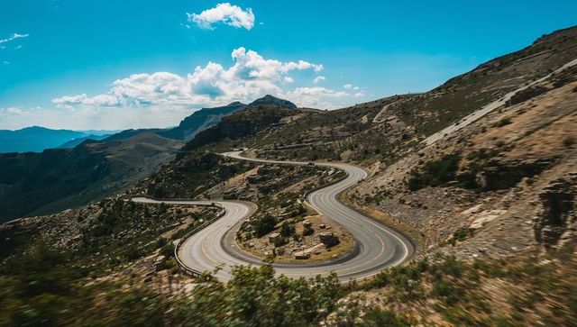 Winding mountain highway with dramatic switchbacks and panoramic alpine vistas