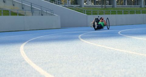 Athlete Racing on Track with Wheelchair in Sport Facility