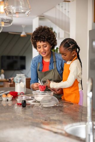 Mother and Daughter Enjoying Baking Together with Mixing Bowl
