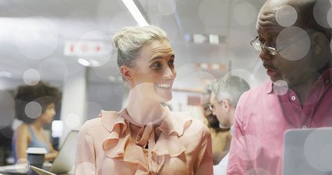 Diverse coworkers engaged in lively office conversation