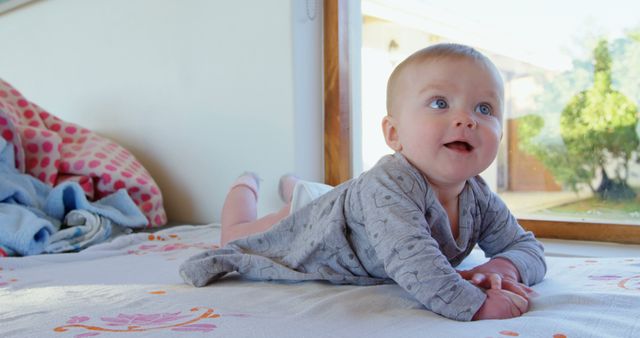 Smiling Baby Lying on Bed in Sunlit Room - Download Free Stock Images Pikwizard.com