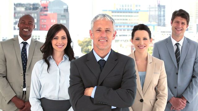 Group of confident business professionals standing with arms crossed in a well-lit, modern office. Ideal for promoting company culture, teamwork, leadership, corporate success and articles on professional development.