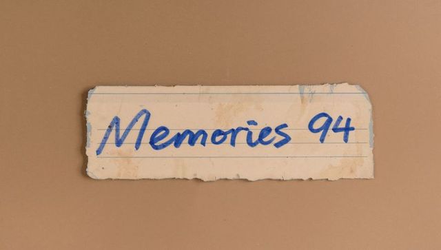 Vintage torn notebook strip featuring memories 94 handwritten label on brown backdrop