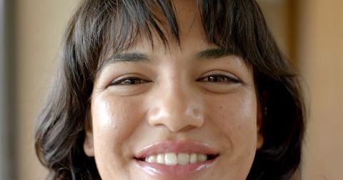Smiling woman with freckles in softly lit room