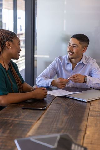 Two Diverse Professionals Discussing Business Strategy over a Laptop