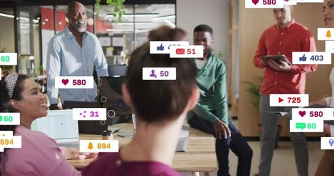 Team collaborating with social media engagement metrics and notifications in open office