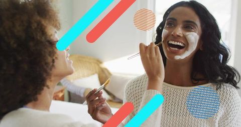 Friends Applying Face Mask Laughing During Cozy At-Home Spa Moment Natural Skincare