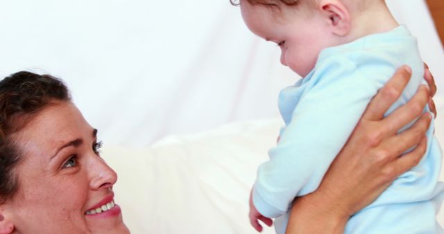 Happy Mother Playing with Baby Indoors in Soft Light - Download Free Stock Images Pikwizard.com