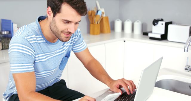 Man Working on Laptop in Modern Kitchen Using Smartphone - Download Free Stock Images Pikwizard.com