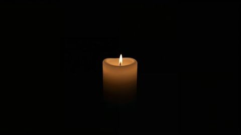 Glowing wax candle casting ambient warm glow in darkness for condolences