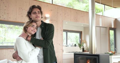 Happy Couple Embracing by Modern Indoor Fireplace
