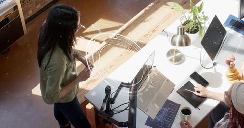 Software developers collaborating on code and data charts in bright coworking office